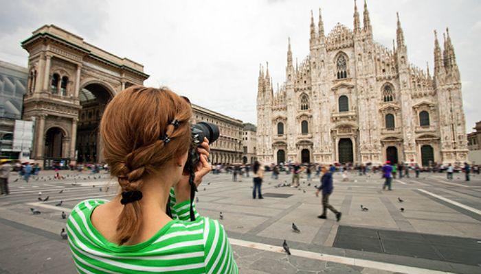 Joven fotografía el Duomo en Milán, Italia