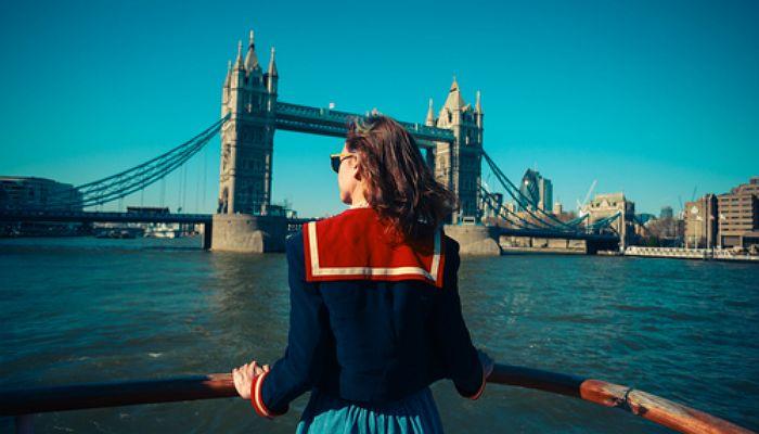 Joven contempla la ciudad de Londres con el Puente sobre el río Támesis de fondo.
