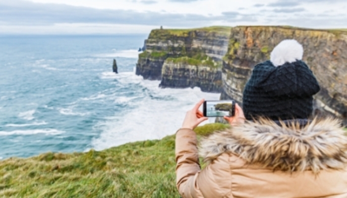 Joven fotografiando los acantilados de Moher, en Irlanda | Ocskay Bence, shutterstock