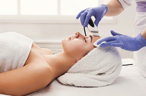 Woman getting facial treatment at beauty salon