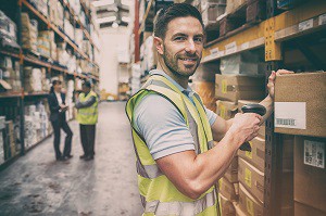 Warehouse worker scanning box while smiling at camera