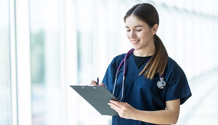 Smiling young female doctor holding a clipboard in hospital. healthcare concept