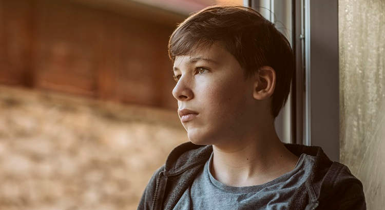 Joven adolescente mirando por la ventana. 