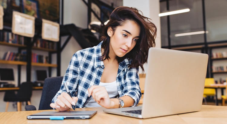Estudiante de FP con el ordenador en el aula. | lookstudio