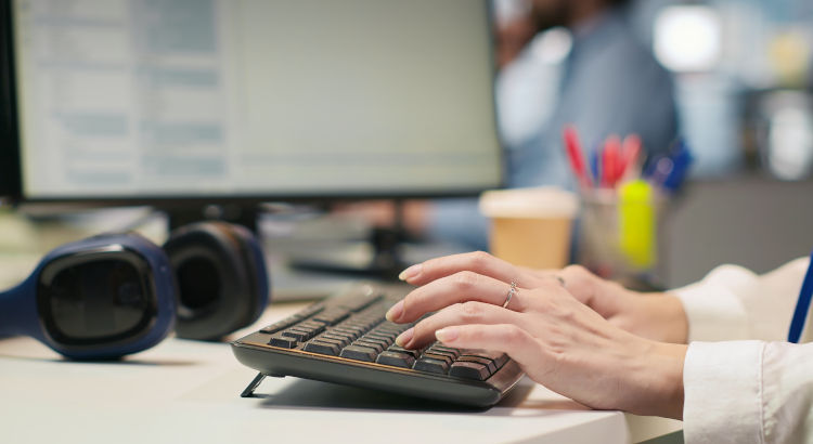 Mujer administrativa trabajando con expedientes en el ordenador. | Foto: DC Studio vía freepik