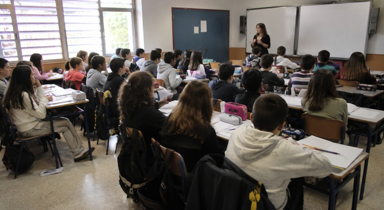 Aula con alumnos y profesora dando clase. 